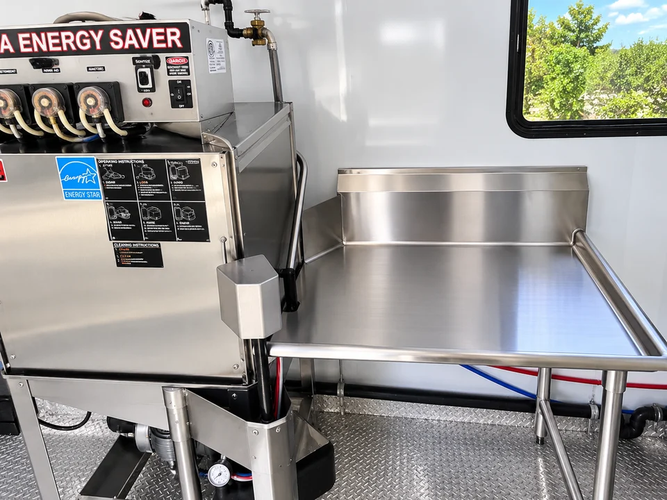 Commercial dishwasher and loading table inside a commercial dishwashing trailer rental
